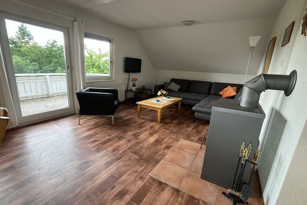 A living room with a sofa, a coffee table, a fireplace, and a television.