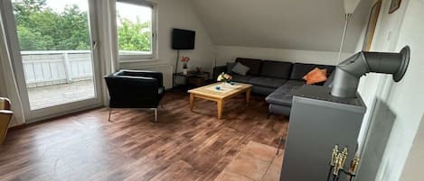 A living room with a sofa, a coffee table, a fireplace, and a television.
