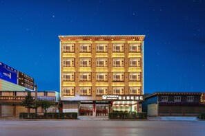 Un hôtel à plusieurs étages, doté d’une façade symétrique, de grandes fenêtres et d’une enseigne indiquant qu’il s’agit d’un hôtel.