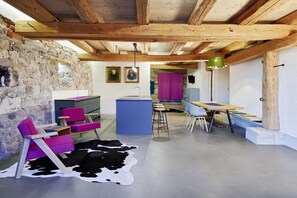 A modern interior with exposed wooden beams, a stone wall, and a cowhide rug. - Holiday apartment with 2 bedrooms (Löffingen)