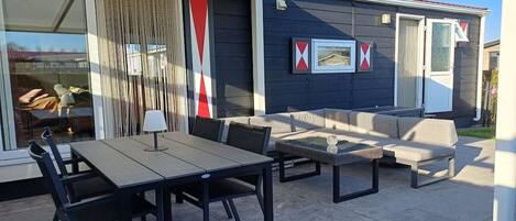 An outdoor patio with a dining table, chairs, and a sofa.
