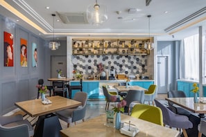A modern restaurant with a central bar area, multiple seating options, and a decorative wall with hexagonal patterns. - Magnotel (Binzhou)
