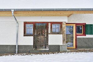 A building with a wooden door, a window, and a door with a green shutter. - Holiday apartment with 2 bedrooms (Löffingen)