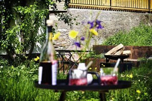 A table with a bottle and glasses, surrounded by greenery and flowers. - Holiday apartment with 2 bedrooms (Löffingen)
