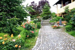 A cobblestone pathway leading to a building with a staircase. - 2 Houses on the edge of the forest (Leutenbach)