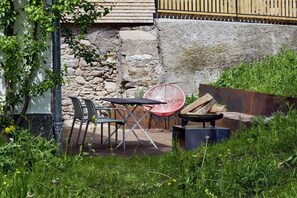 An outdoor seating area with a table and chairs, a hammock, and a rustic wooden bench. - Holiday apartment with 2 bedrooms (Löffingen)