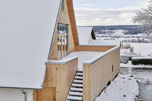 A modern building with a sloped roof, wooden exterior walls, and a staircase leading to an upper level. - Holiday apartment with 2 bedrooms (Löffingen)