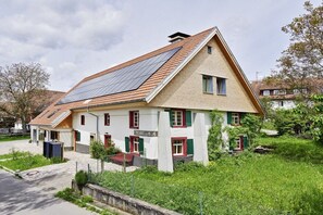A two-story building with a sloped roof, solar panels, and a sign that reads 'SCHELLIS'. - Holiday apartment with 3 bedrooms (Löffingen)
