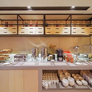 A buffet setup with various food items, a coffee machine, and a toaster. - Echarm Hotel (Guangzhou)