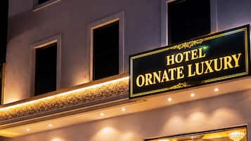 Entrada de un hotel con un letrero que dice 'HOTEL ORNATE LUXURY'.