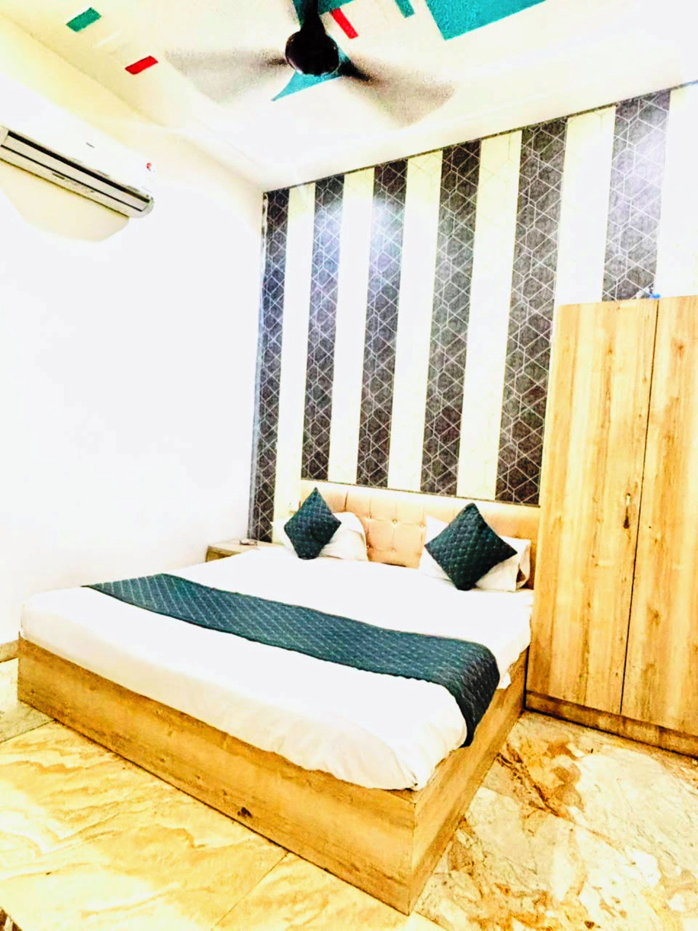 Un dormitorio con cama, cabecera de madera y ventilador de techo.