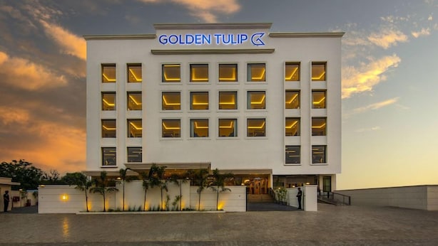 A modern hotel building with a prominent sign reading 'GOLDEN TULIP.' - Grandville Hotel Pousada (Barra de São Miguel)
