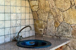 A bathroom with a stone wall, a tiled wall, and a blue sink. - Villa in Monticello with swimming pool (MONTICELLO)