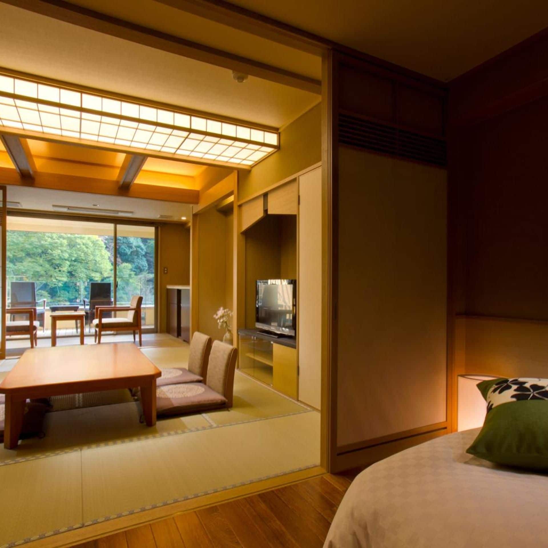 Une pièce de style japonais traditionnel, avec un sol recouvert de tatamis, une table basse, un canapé et un lit.