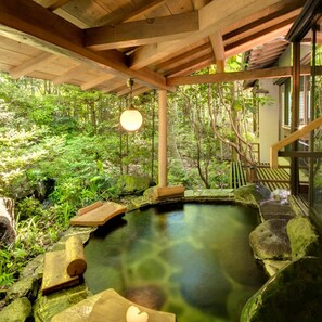 A tranquil indoor garden with a clear water feature, wooden benches, and a hanging light fixture. - Shimoda Rendaiji Onsen Seiryuso (Shimoda)