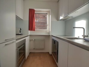 A compact kitchen with a window, a radiator, and a dishwasher. - L'Orée 12 Appartement/Fewo 4-Bettwohnung by Interhome (Saas-Fee)
