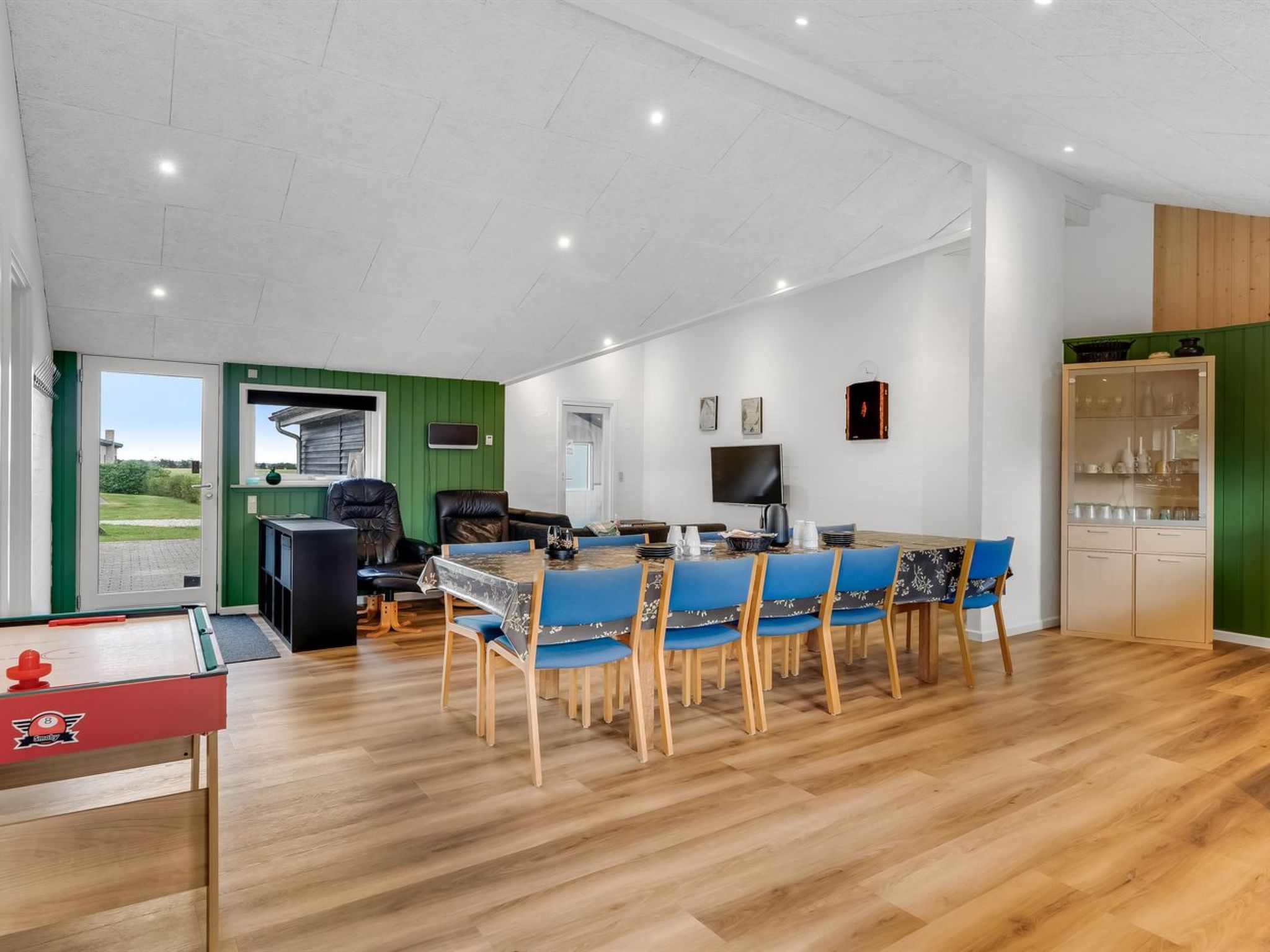 Amplia habitación con mesa de comedor, sillas, mesa de billar y zona de cocina.