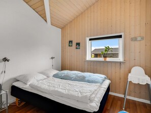 A bedroom with a bed, a window, and a plant. - "Nahuel" - 300m to the fjord by Interhome (Vinderup)