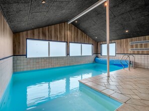 A swimming pool with a tiled deck, wooden walls, and large windows. - "Nahuel" - 300m to the fjord by Interhome (Vinderup)