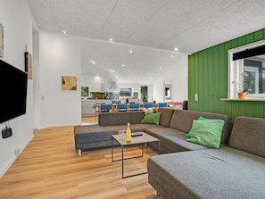 A modern living room with a sectional sofa, a coffee table, and a flat-screen TV. - "Nahuel" - 300m to the fjord by Interhome (Vinderup)