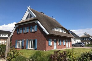 A red brick house with blue shutters, a sloped roof, and a visible chimney. - Stork's Nest House (1) (Dranske \/ OT lancken)