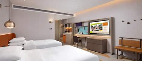 A hotel room with two beds, a desk, a bench, and a TV displaying a magazine.