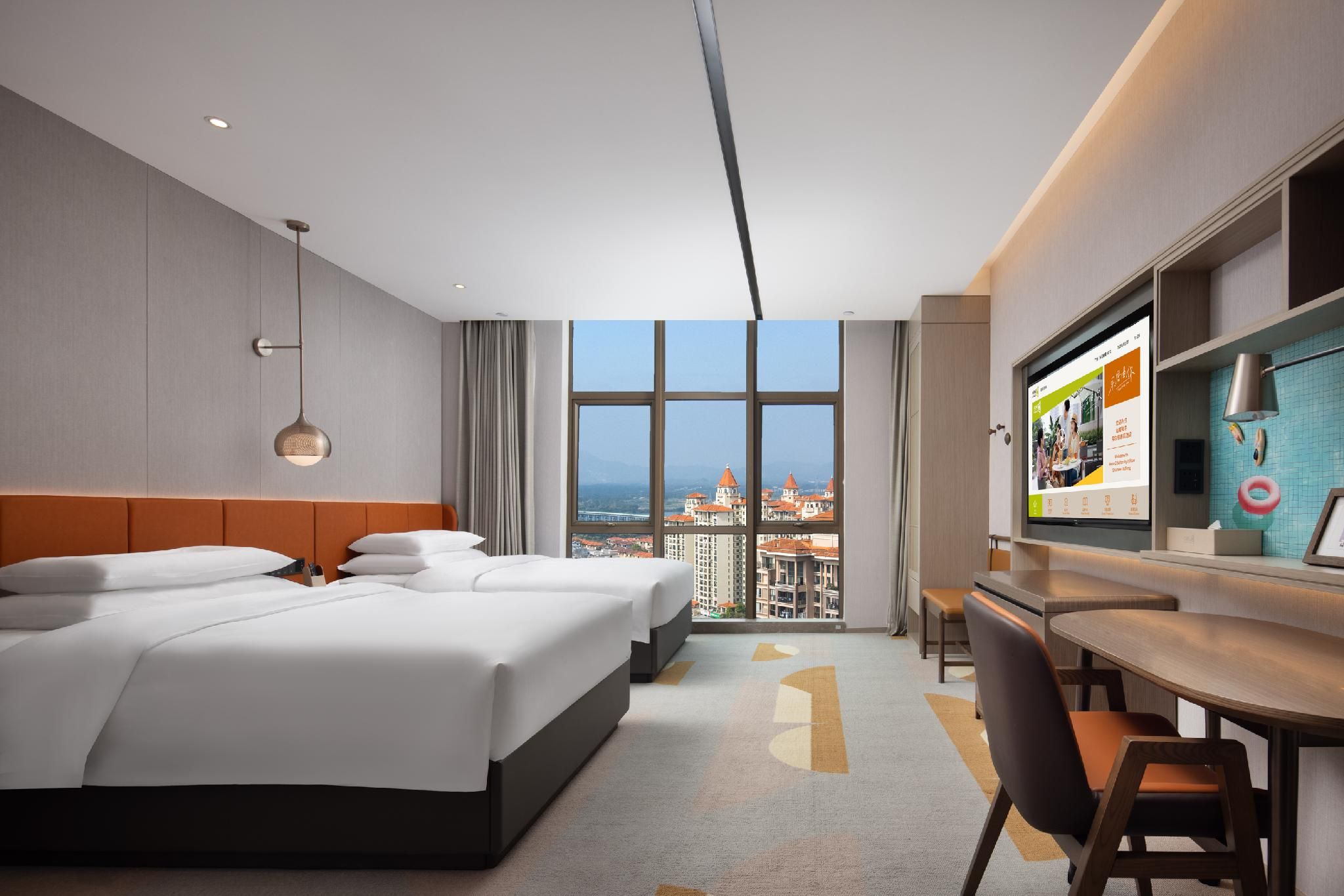 Une chambre d’hôtel avec un grand lit, un bureau équipé d’un ordinateur et une vue sur le paysage urbain par la fenêtre.