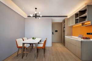 Una cocina moderna con armarios empotrados, una encimera y un comedor con mesa y sillas.