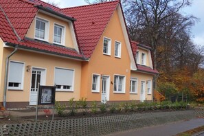 A two-story house with a red-tiled roof and a beige facade. - Holiday apartment with 2 bedrooms (Kölpinsee)