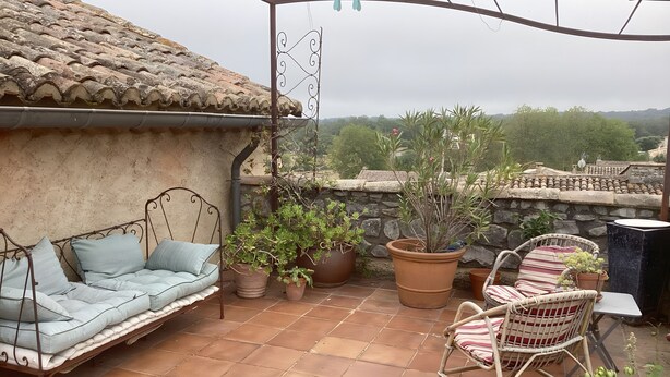 A patio with a sofa, chairs, and potted plants. - Charming Guest Room with Historic Character and Terrace (Fons-sur-Lussan)
