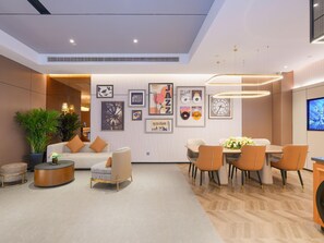 A modern interior with a dining area, seating, and wall art. - Homeinn Plus (Suzhou)
