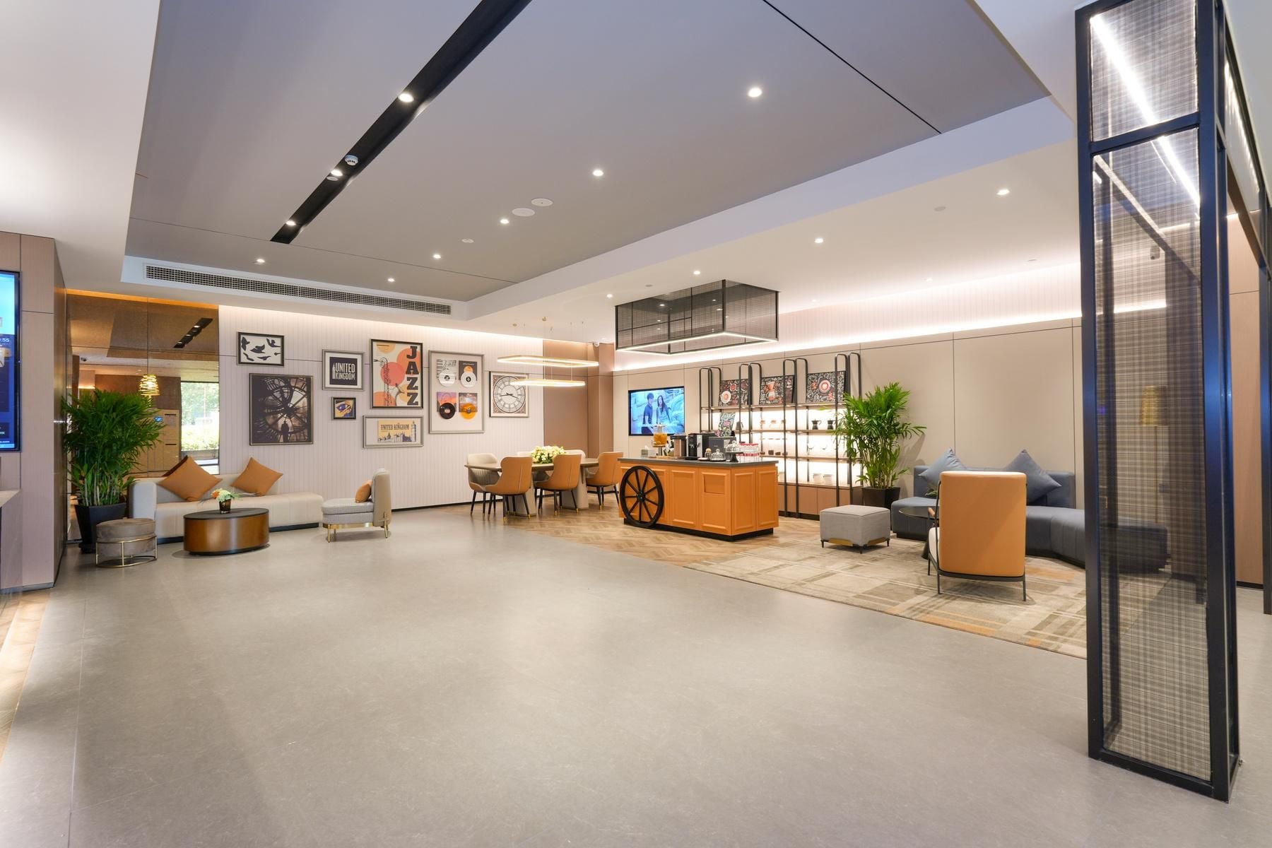 A modern hotel lobby with a reception desk, seating area, and artwork on the walls.