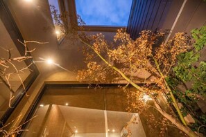 Interior moderno com claraboia, teto de vidro e um arranjo de plantas.