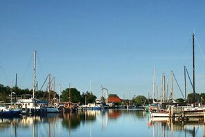 Ein Yachthafen mit mehreren angedockten Booten, ruhigem Wasser und klarem Himmel.