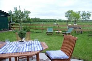 A patio with a table, chairs, and a small garden area. - Holiday apartment in Jade with barbecue (Jade)