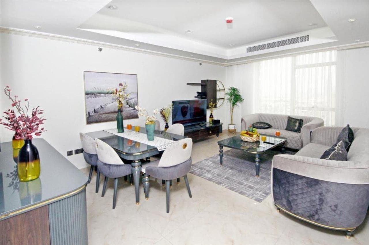Een moderne woonkamer met een eethoek, een bank en een televisie.