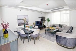 A modern living room with a dining area, a sofa, and a TV.