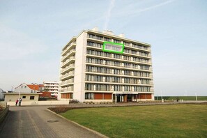 A multi-story hotel with a central entrance, a flat roof, and a surrounding grassy area. - Kaiserhof with sea view - Spa Zone 1 (Norderney)