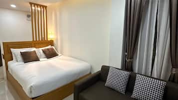 Ein Hotelzimmer mit einem Bett, einem Sofa und einem Vorhang.