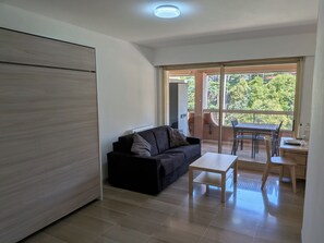 Ein modernes Wohnzimmer mit einer Couch, einem Couchtisch und einem Essbereich mit Tisch und Stühlen.