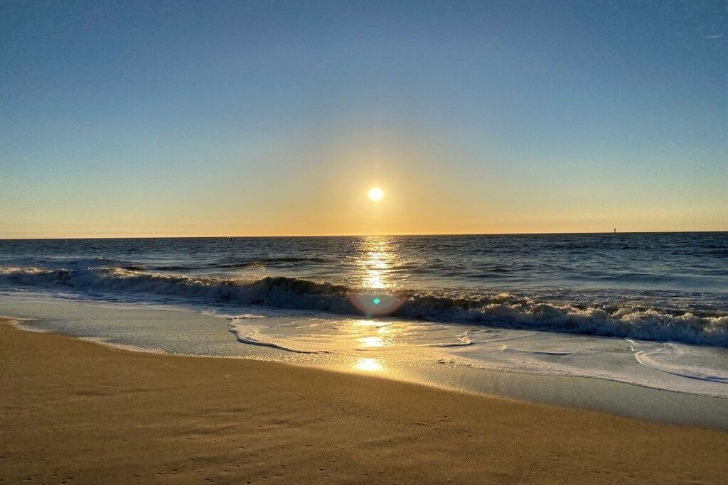 Une plage avec des vagues et un ciel dégagé.