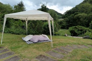 A tent set up on a grassy area with a stone pathway leading to it. - Holiday home with 4 bedrooms (Brodenbach  Ehrenburgertal)