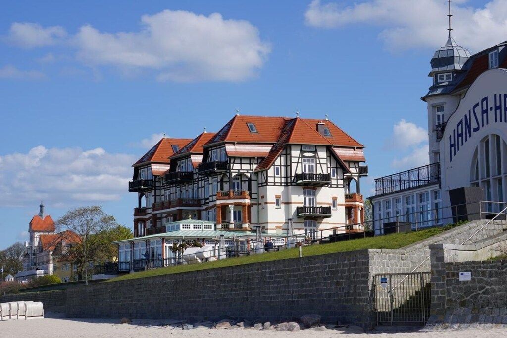 Un edificio de varios pisos con arquitectura europea tradicional, que destaca un balcón y una escalera que lleva a la entrada.
