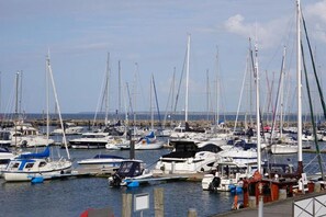 Un port de plaisance où de nombreux voiliers sont amarrés à des quais en bois.