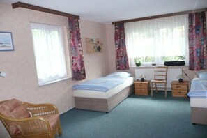 A bedroom with a single bed, a chair, a desk, and a window with curtains. - 1 - Holiday home Schmidt (Ostseebad Prerow)