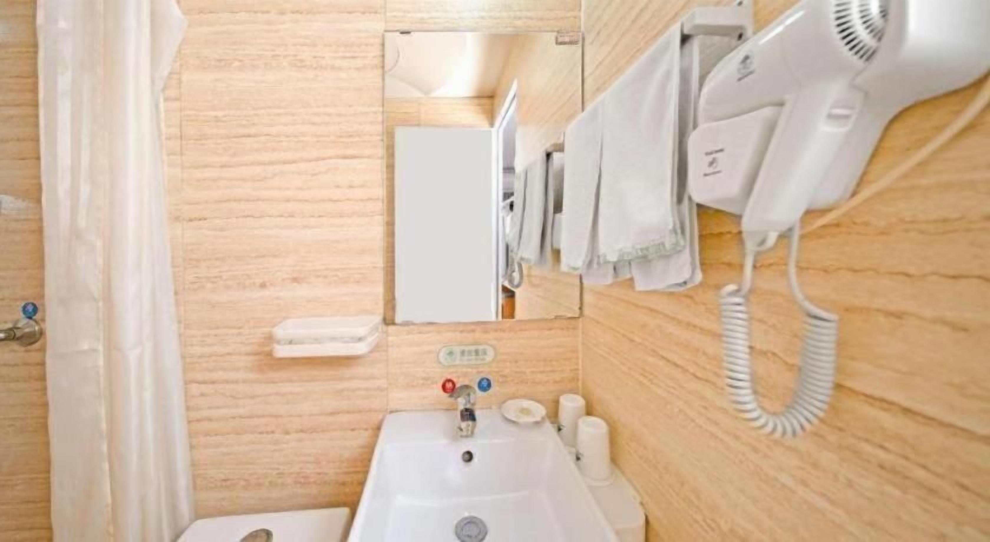 A bathroom with a sink, a mirror, a hairdryer, and a towel rack.