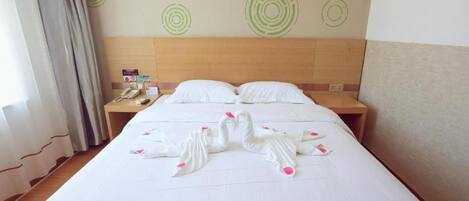 Habitación de hotel con una cama, dos mesitas de noche, un teléfono y una pared con diseños circulares.