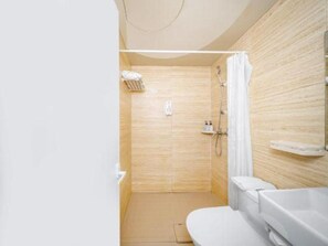 Un baño moderno con ducha, inodoro y lavamanos.