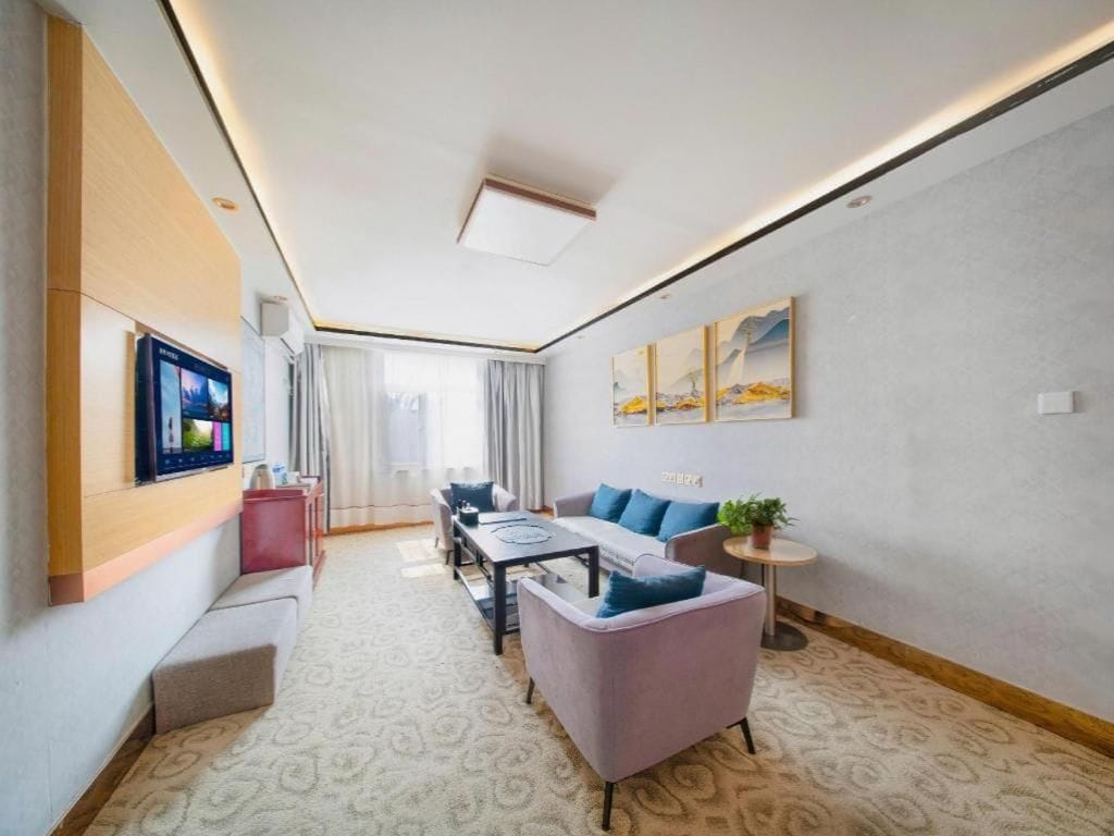 A modern living room with a sofa, a coffee table, and a TV mounted on the wall.