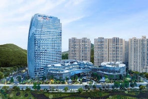 A modern hotel complex with a prominent curved building and several high-rise residential towers.